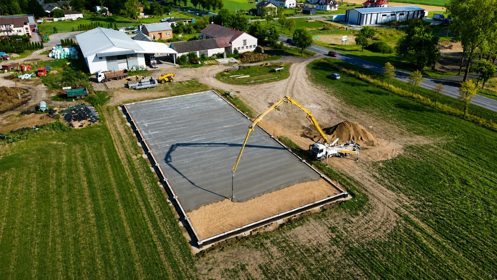 Betonowanie dużej płyty fundamentowej pompą, widok z drona